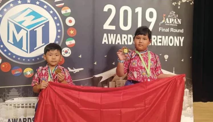 Dua siswa Kasih Baptist membawa medali dan bendera Indonesia pada final WMI 2019 di Jepang